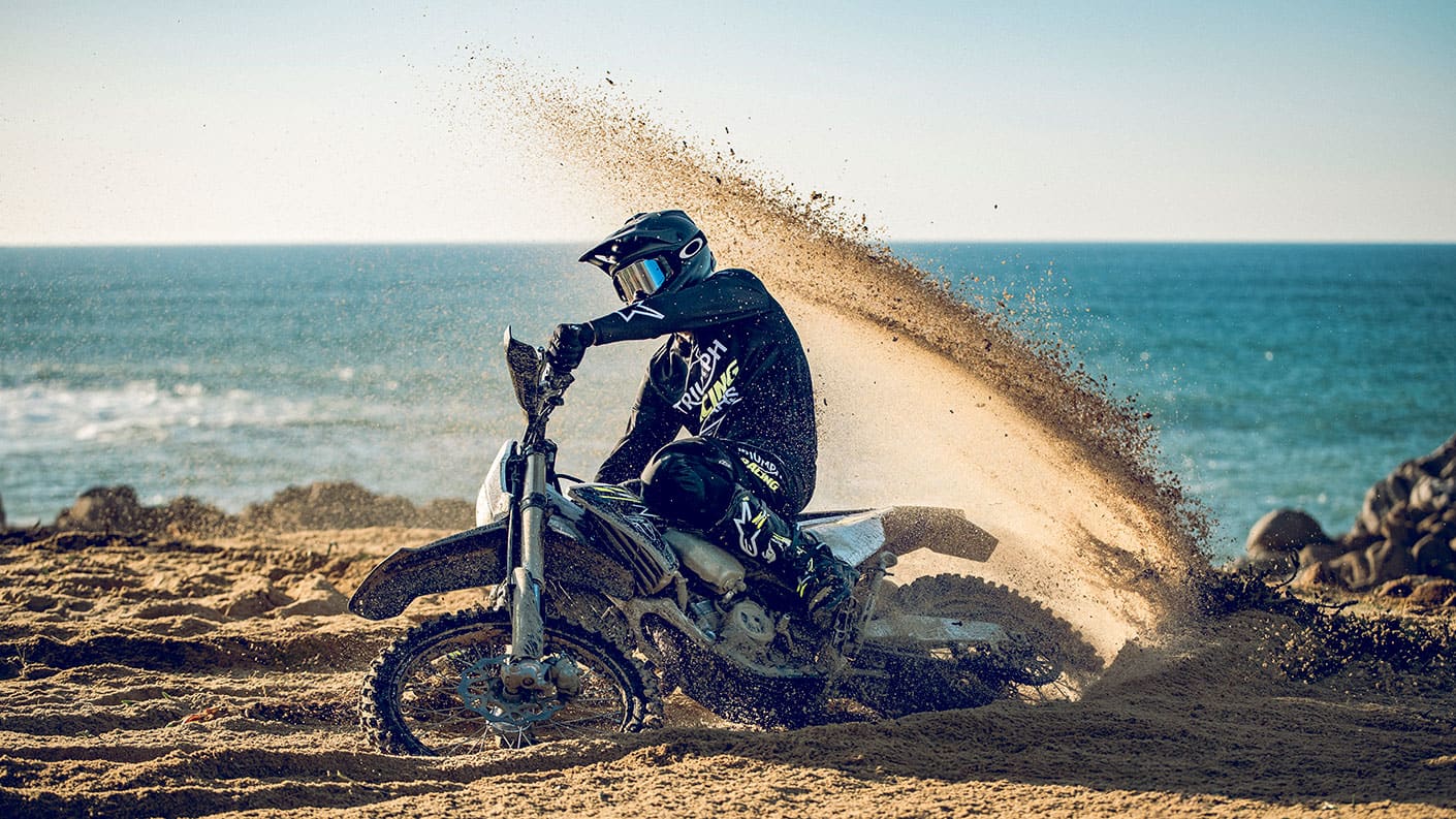 Triumph TF 450-E riding shot with mud flying up