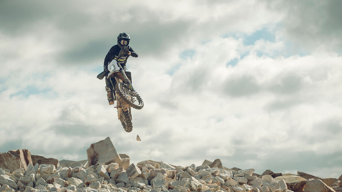 Triumph TF 450-E riding shot in the air over white rocks