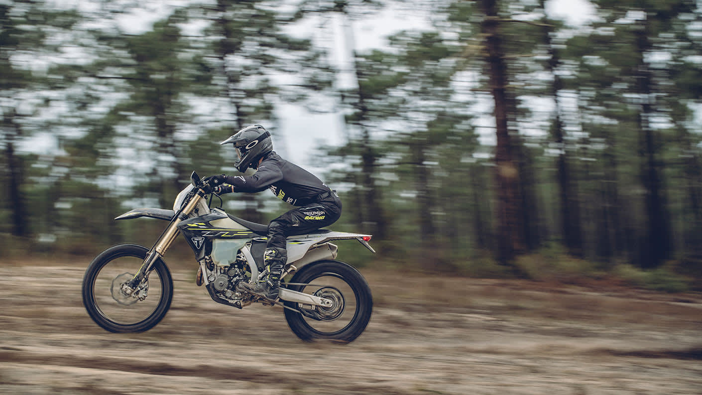 Triumph TF 450-E riding shot through trees