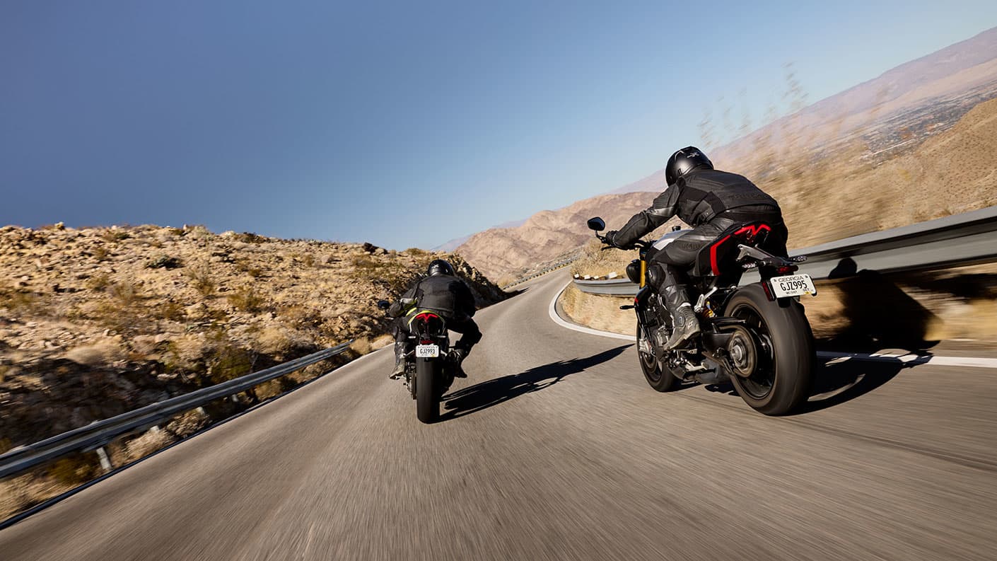 Rear shot of the Triumph Speed Triple 1200 RS ridden by two riders